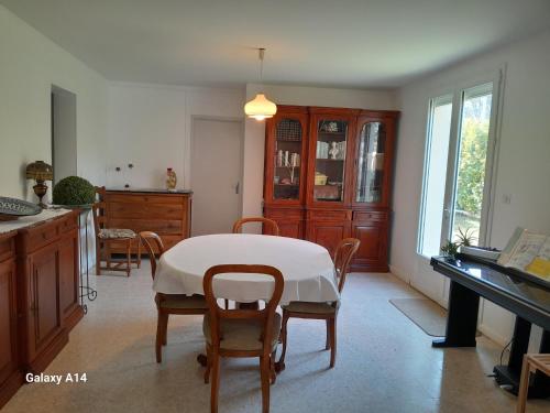 eine Küche mit einem Tisch, Stühlen und einem Klavier in der Unterkunft Un logement dans pavillon Pèzenas in Pézenas