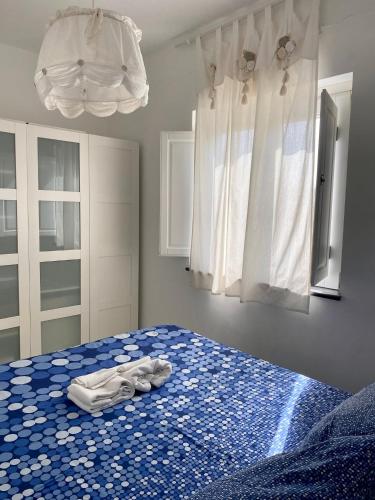 a bedroom with a blue bed with towels on it at Dolcevita Villa in Vulcano in Vulcano