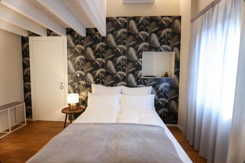 1 dormitorio con cama y pared con papel pintado de pájaro en Room & Breakfast Civico 07, en Fontanellato