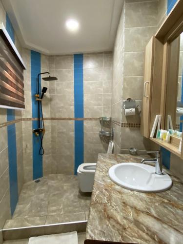 a bathroom with a sink and a toilet at Bays Lodge, Accra in Accra