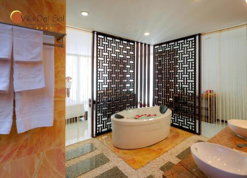 a bathroom with a tub and two sinks in it at Villa Del Sol Beach Resort & Spa in Phan Thiet