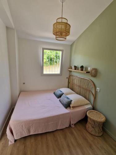 une chambre avec un grand lit avec une fenêtre dans l'établissement La p'tite cabane - Maisonnette Carnon Plage, à Carnon-Plage