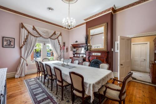 a dining room with a table and chairs at The Red Door: Expansive Home/Pool/4 BR w Ensuites in Glenelg