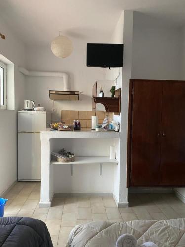 a kitchen with a counter and a tv in a room at Alexandra Studios in Néos Pírgos