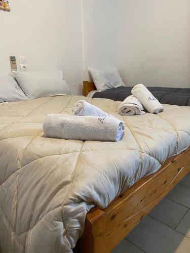 two twin beds with towels on top of them at Alexandra Studios in Néos Pírgos