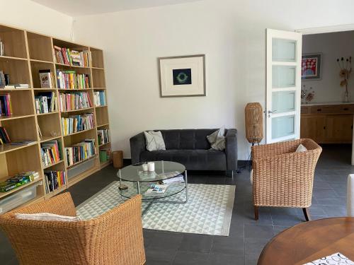 a living room with a couch and a table and book shelves at Vakantiehuis De Zeeuwse Schuur in de Zak van Zuid-Beveland in Heinkensand