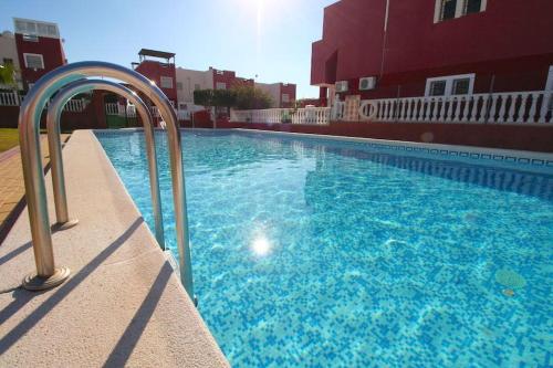 einem Pool mit blauem Wasser vor einem Gebäude in der Unterkunft Ground floor apartment Torrevieja Spain in Orihuela