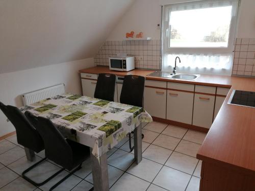 a kitchen with a table and chairs and a sink at Ferienwohnung Fleischer in Mitterteich