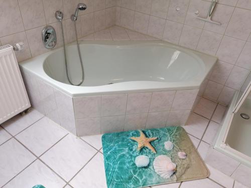 a bathroom with a tub and a starfish on a rug at Ferienwohnung Fleischer in Mitterteich