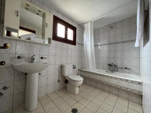 梅加利阿莫斯的住宿－Villa Pigadi，浴室配有卫生间、盥洗盆和浴缸。