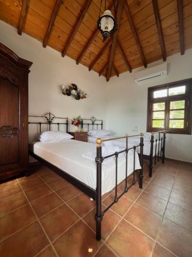 Villa Pigadi في شاطئ ميغالي أموس: غرفة نوم بسريرين وسقف خشبي