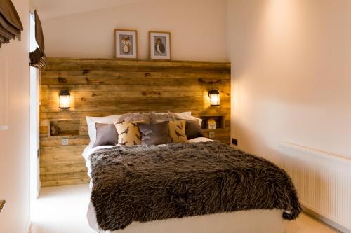 a bedroom with a wooden accent wall and a bed at Lochness lodge in Fort Augustus
