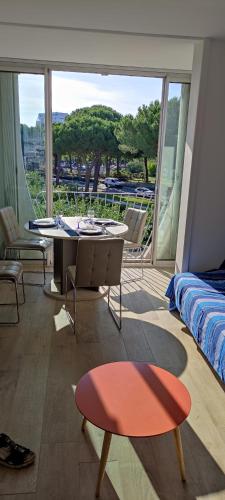 une chambre avec un lit, une table et des chaises dans l'établissement Studio climatisé avec parking et wifi au Couchant, à La Grande Motte