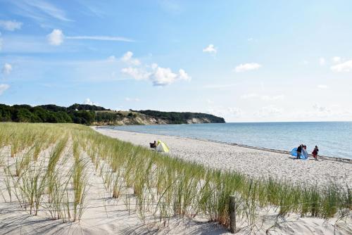 a group of people walking on a beach at Strandhaus Goehren in Göhren