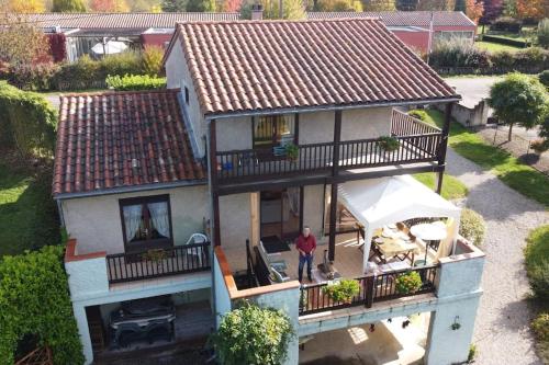 a man standing on the balcony of a house at French Pyrenees Luxury in Serres-sur-Arget