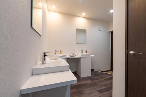 a bathroom with two sinks and a mirror at Hostel JAQ takamatsu in Takamatsu