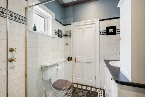 a bathroom with a toilet and a sink at The Red Door: Expansive Home/Pool/4 BR w Ensuites in Glenelg