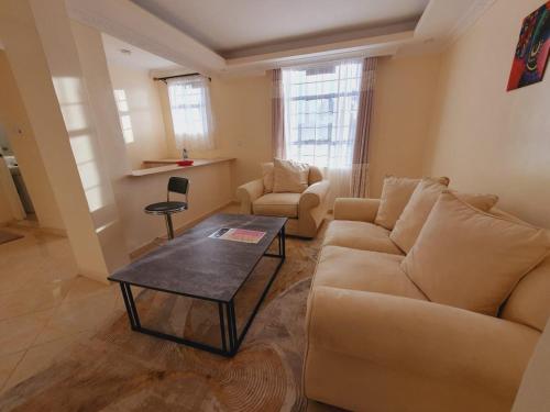 a living room with a couch and a table at COMFORT E SUITES in Nairobi