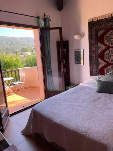 - une chambre avec un lit et une vue sur un balcon dans l'établissement Villa U Castellu vue mer imprenable, à Coti-Chiavari