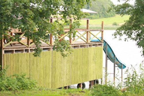 a playground with a slide next to a body of water at Sodyba Brazylija in Taraldžiai