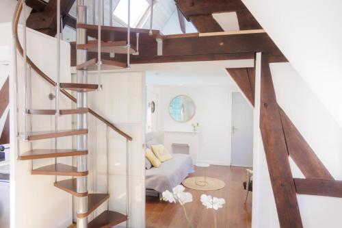 a spiral staircase in a room with a living room at Domaine de l’Orangerie - La Suite Eucalyptus in Boissise-la-Bertrand