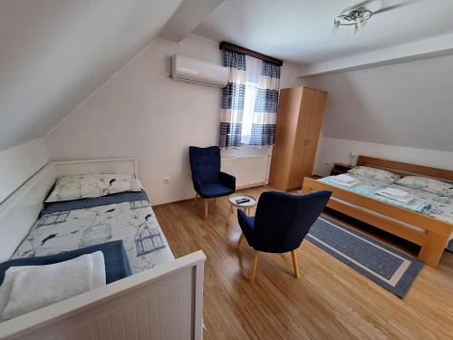 a bedroom with a bed and two chairs in it at Guest House Matej & Mateja in Plitvička Jezera