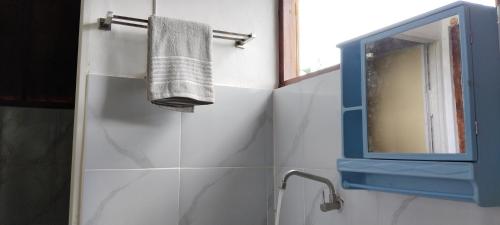 uma casa de banho com um lavatório, um espelho e uma toalha em Nan Bungalows Tetebatu em Tetebatu