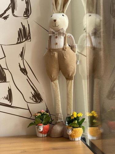 a stuffed rabbit standing on a shelf next to some plants at Leśny Wierch luxury spa villas in Bukowina Tatrzańska