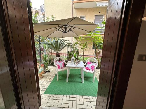 a table with two chairs and an umbrella at Casa Patrizia in Giardini Naxos