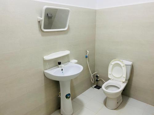 ein Bad mit einem WC und einem Waschbecken in der Unterkunft White Villa Hotel in Trincomalee