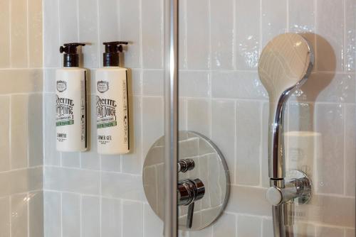 a shower with two shampoo bottles in a bathroom at LE CLARK HOTEL in Paris