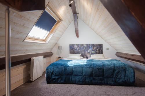 a bedroom with a large bed in a attic at Domaine de l’Orangerie - La Suite Eucalyptus in Boissise-la-Bertrand
