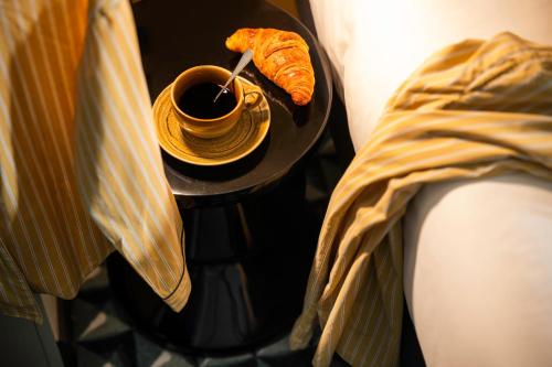a cup of coffee and a croissant on a table at LE CLARK HOTEL in Paris