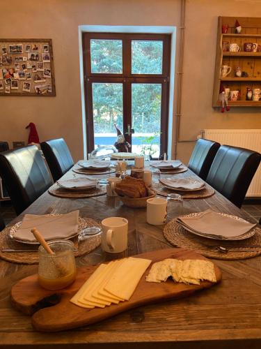 een houten tafel met borden en keukengerei erop bij La Libellule in Couvin