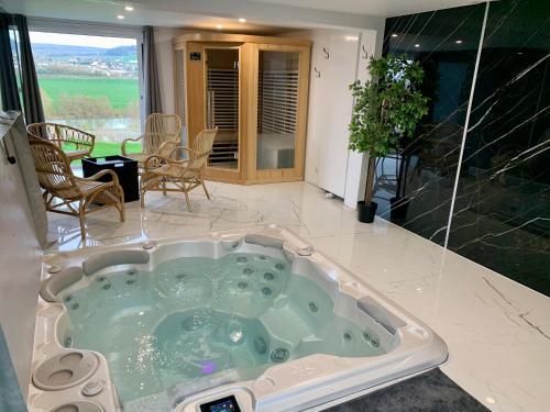 uma banheira de hidromassagem no meio de um quarto em Le Spanorama; gîte premium em Vincelles