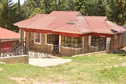 una pequeña casa con techo rojo en THE FARM BAR AND RESTAURANT, en Kakamega