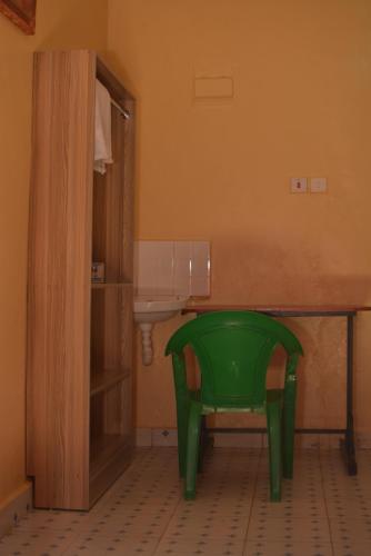 een groene stoel in een badkamer met een wastafel bij THE FARM BAR AND RESTAURANT in Kakamega
