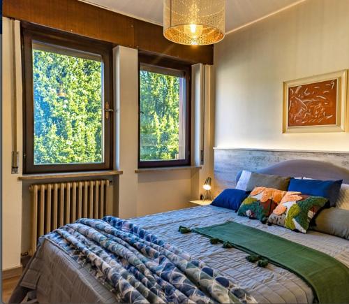 um quarto com uma cama grande e 2 janelas em Asiago Plateau New Modern House em Asiago