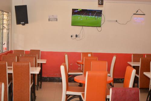 a classroom with tables and chairs and a tv on the wall at THE FARM BAR AND RESTAURANT in Kakamega