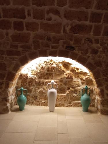 three vases sitting in a brick wall with an arch at N'incanto in Rutigliano