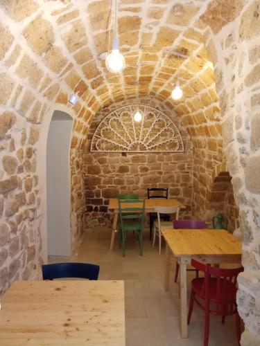 a room with tables and chairs in a stone wall at N'incanto in Rutigliano