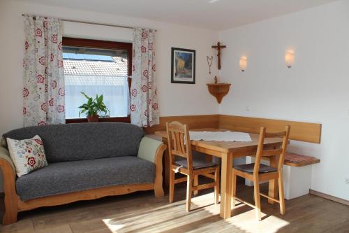 a living room with a couch and a table and chairs at Ferienwohungen Familie Schröttle in Sonthofen