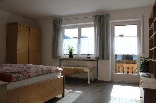 a bedroom with a bed and two windows at Ferienwohungen Familie Schröttle in Sonthofen