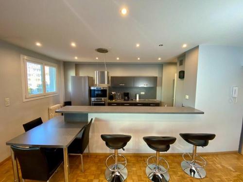 - une cuisine avec une table et quelques tabourets de bar dans l'établissement Le Puy en Velay centre, au Puy-en-Velay