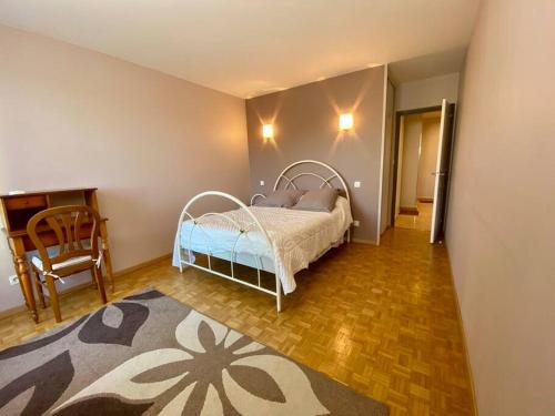 une chambre avec un lit, une table et une chaise dans l'établissement Le Puy en Velay centre, au Puy-en-Velay