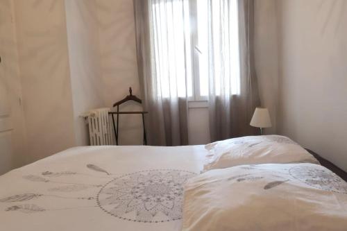 une chambre avec un lit blanc avec une fenêtre dans l'établissement Cosy Catalan, à 50m de la plage, à Marseille