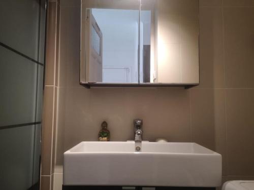 une salle de bain avec un lavabo blanc et un miroir dans l'établissement Cosy Catalan, à 50m de la plage, à Marseille