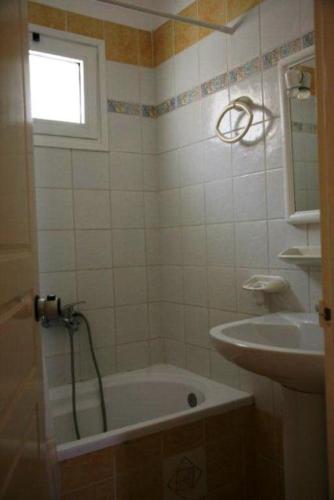 a bathroom with a bath tub and a sink at Villa Sofia in Skala