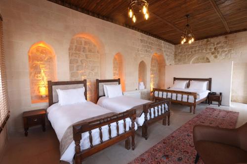 a bedroom with two beds and two benches in it at Marvel Hotel in Mardin