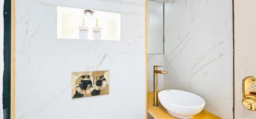 a white bathroom with a toilet and a window at Hotel Nova Bling in Rajkot